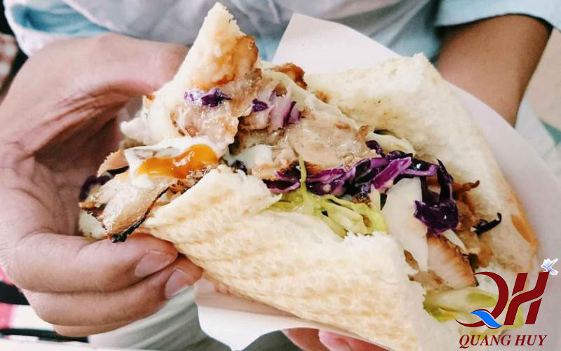Trên tay chiếc bánh mì Doner kebab thơm ngon với thịt nướng, sốt và rau củ thanh mát
