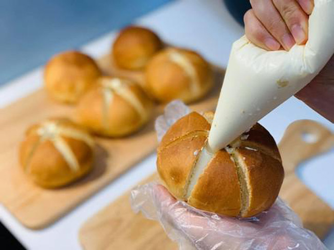 Bơm kem vào giữa bánh, làm bánh mì bơ tỏi